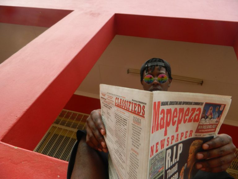 Model Fezile Mnisi holding the Mapepeza Community Newspaper. Photo by Percival Moloi (Ratanda, South Africa). Copyright reserved.