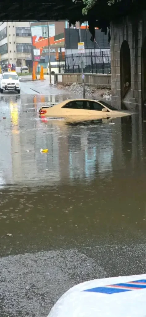 A vehicle is floating on a body of water at the intersection of Siemert Road and Currey Street in Doornfontein on Saturday, September 6, as heavy rains poured in the area. Image from JMPD